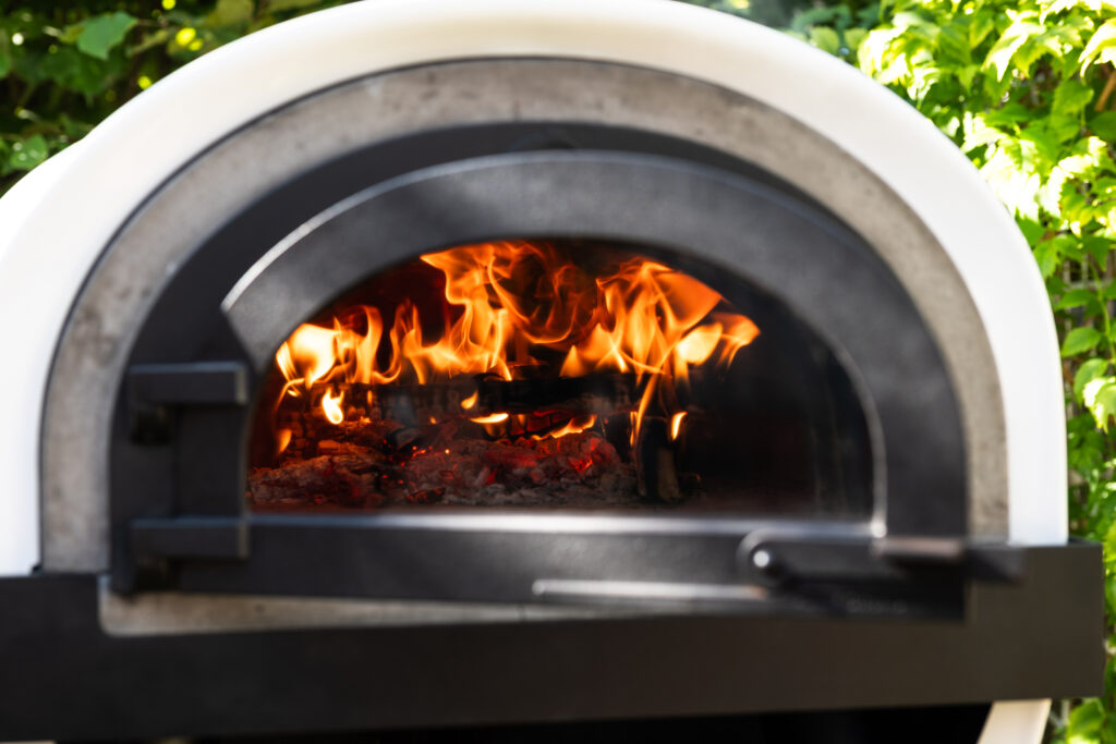 Flammes à travers une porte vitrée de four à bois